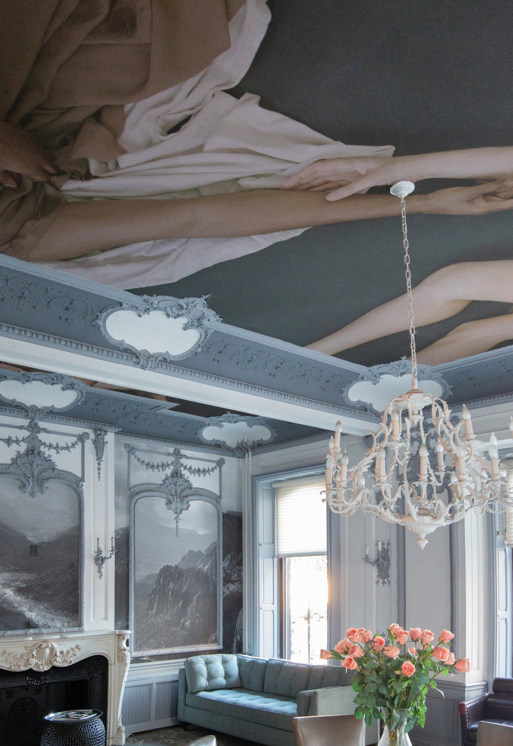 A luxurious room with a renaissance style mural on the ceiling.