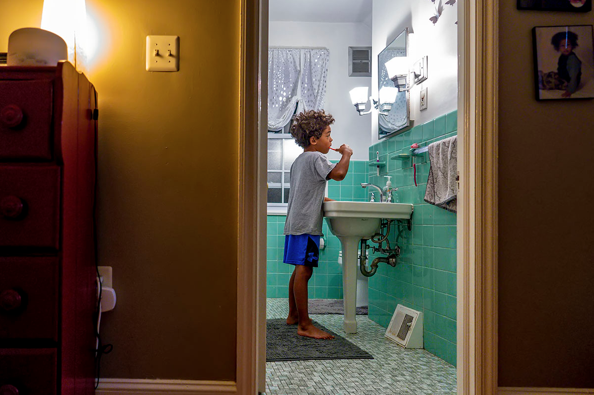 Child in a bathroom brushing their teeth.